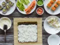 Idealny ryż do sushi jest kleisty i gotowy do zwinięcia z nori, łososiem i awokado.
