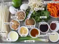 Składniki do sosu pad thai: makaron ryżowy, jajka, orzeszki ziemne, masło orzechowe, olej, czosnek, zielona cebulka, brązowy cukier, kiełki fasoli, kolendra, marchewka, papryka, sos sojowy, sos rybny, ocet ryżowy, sriracha, limonka.