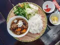 Pyszne bun chay: grillowane mięso, ryżowy makaron, świeże zioła, warzywa, chili i cytryna.