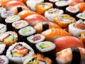 Różnorodne sushi, w tym rolki z łososiem i awokado, idealne dla dzieci. Czy dzieci mogą jeść sushi? Tak, jeśli wybierzemy łagodne składniki!