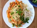 Pyszny pad thai oryginalny przepis z kurczakiem, warzywami i orzeszkami ziemnymi.
