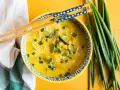 Aromaticzna zupa carry z makaronem ryżowym, warzywami i szczypiorkiem, gotowa do jedzenia pałeczkami.