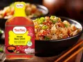 Butelka słodko ostrego sosu chili TaoTao obok miski ryżu z dodatkami. Idealny do mięs i kanapek.