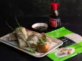 Pyszne sushi w papierze ryżowym, posypane sezamem, podane z sosem sojowym. Obok opakowanie papieru ryżowego.