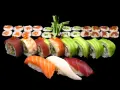 Różnorodne sushi: nigiri z łososiem, tuńczykiem i kalmarem, rolki z awokado, krewetką, tuńczykiem i krabem. Idealne na początek przygody, jak jeść sushi.