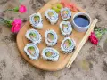 Pyszne california sushi z łososiem i awokado, posypane czarnym sezamem, podane z sosem sojowym i wasabi.