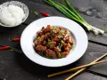 Pyszny kurczak po wietnamsku przepis na talerzu, z ryżem, chili i szczypiorkiem. Idealny na obiad.
