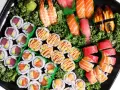 Taca pełna sushi z Japonii: rolki z tuńczykiem i awokado, łososiem, krewetkami, nigiri z łososiem, tuńczykiem i węgorzem.