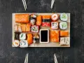 Na desce ułożono różnorodne sushi. Ile kawałków sushi na osobę? Zależy od apetytu, ale jest tu spory wybór!