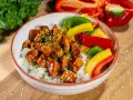 Pyszny kurczak z gotowym sosem teriyaki na ryżu, z kolorową papryką i szczypiorkiem.