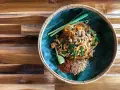 Pyszne pad thai skladniki: makaron ryżowy, kiełki, szczypiorek, orzeszki ziemne, chili i limonka na liściu bananowca.