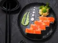 Roladki sushi z łososiem i ikrą, podane z zielonym, pikantnym wasabi prawdziwe, imbirem i sosem sojowym.