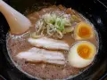 Aksamitny bulion, dwa połówki jajka na miękko, plastry boczku i szczypiorek tworzą apetyczny ramen z boczkiem.