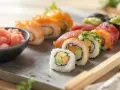 Różnorodne sushi z łososiem i awokado, obok miseczka z różowym, imbir marynowany.
