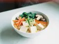 A miseczce ramenu z kostkami tofu, marchewką, szpinakiem i grzybami shiitake.