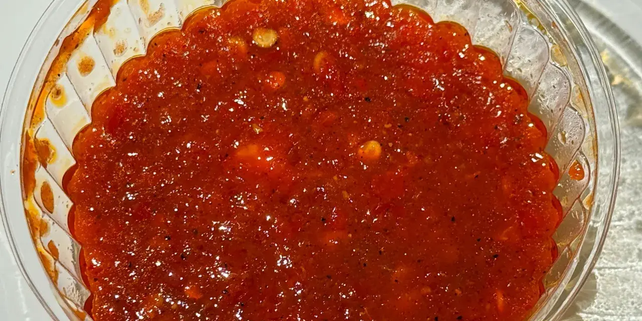 Ostre, czerwone sambal w przezroczystym pojemniku. Idealne do potraw, gdy zastanawiasz się, sambal co to jest i chcesz dodać pikanterii.
