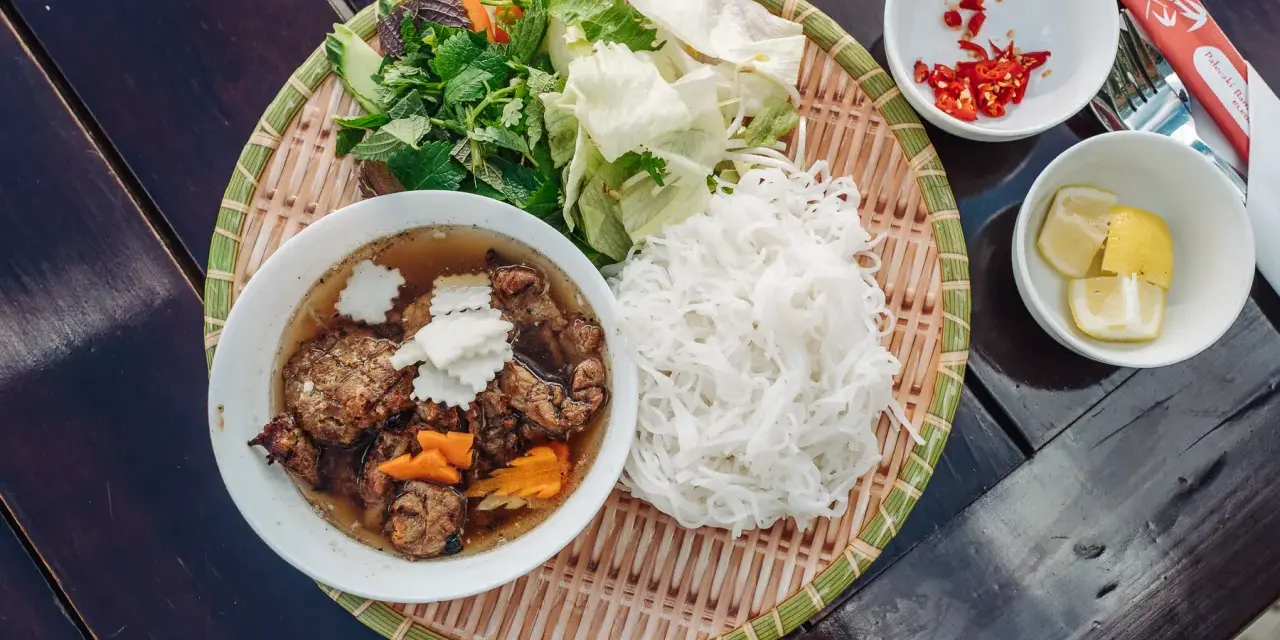 Pyszne bun chay: grillowane mięso, ryżowy makaron, świeże zioła, warzywa, chili i cytryna.