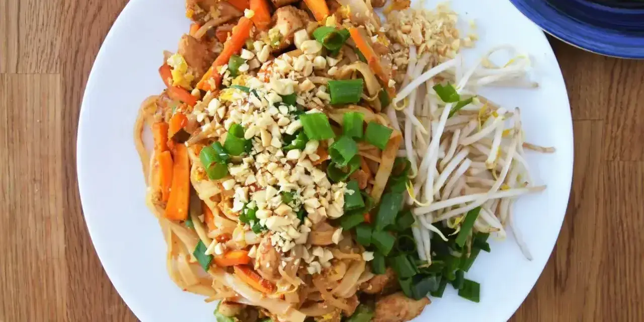 Pyszny pad thai oryginalny przepis z kurczakiem, warzywami i orzeszkami ziemnymi.