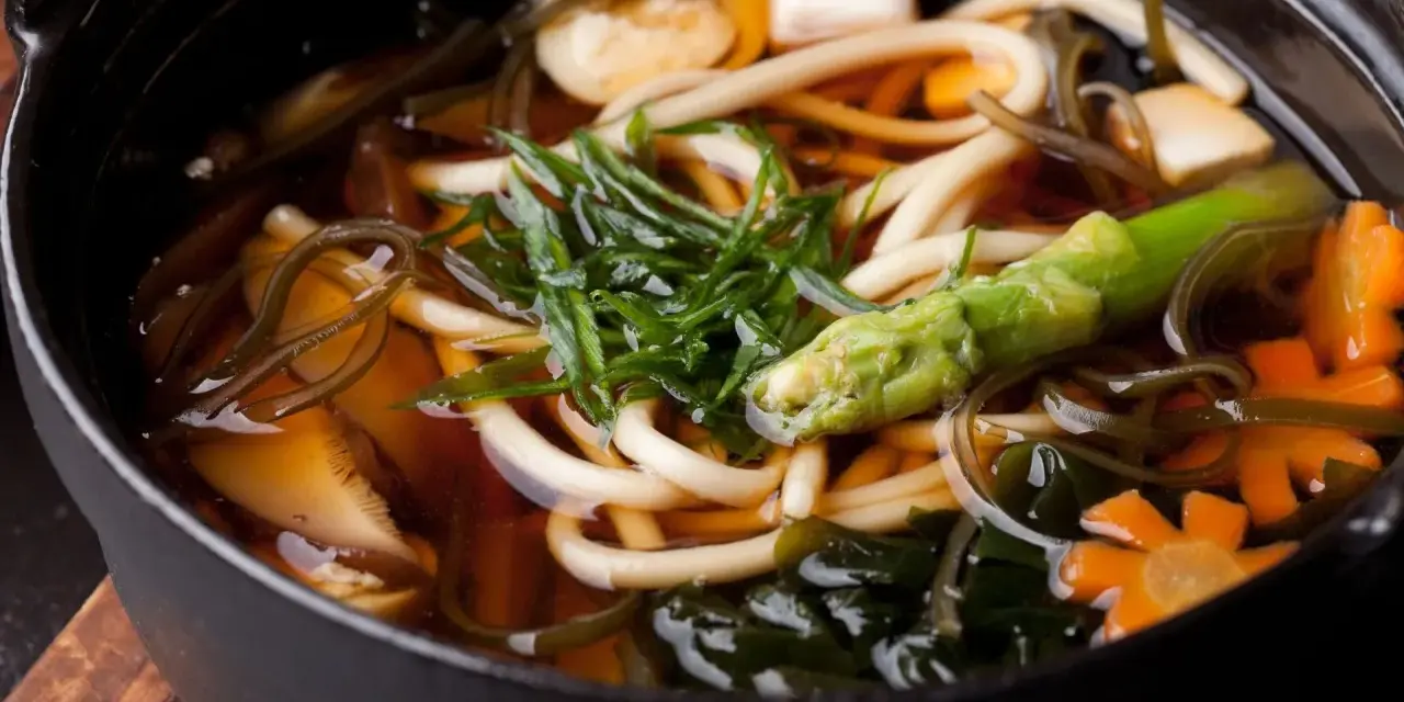 Gęsta zupa z grubym makaronem udon, tofu, warzywami i wodorostami w aromatycznym bulionie dashi.
