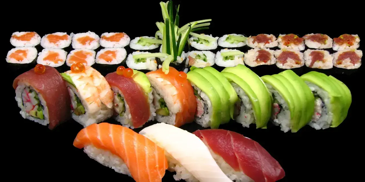 Różnorodne sushi: nigiri z łososiem, tuńczykiem i kalmarem, rolki z awokado, krewetką, tuńczykiem i krabem. Idealne na początek przygody, jak jeść sushi.
