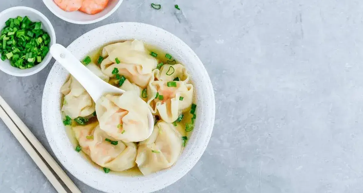 Aksamitna zupa won ton z krewetkami i szczypiorkiem, gotowa do zanurzenia się w jej smaku.