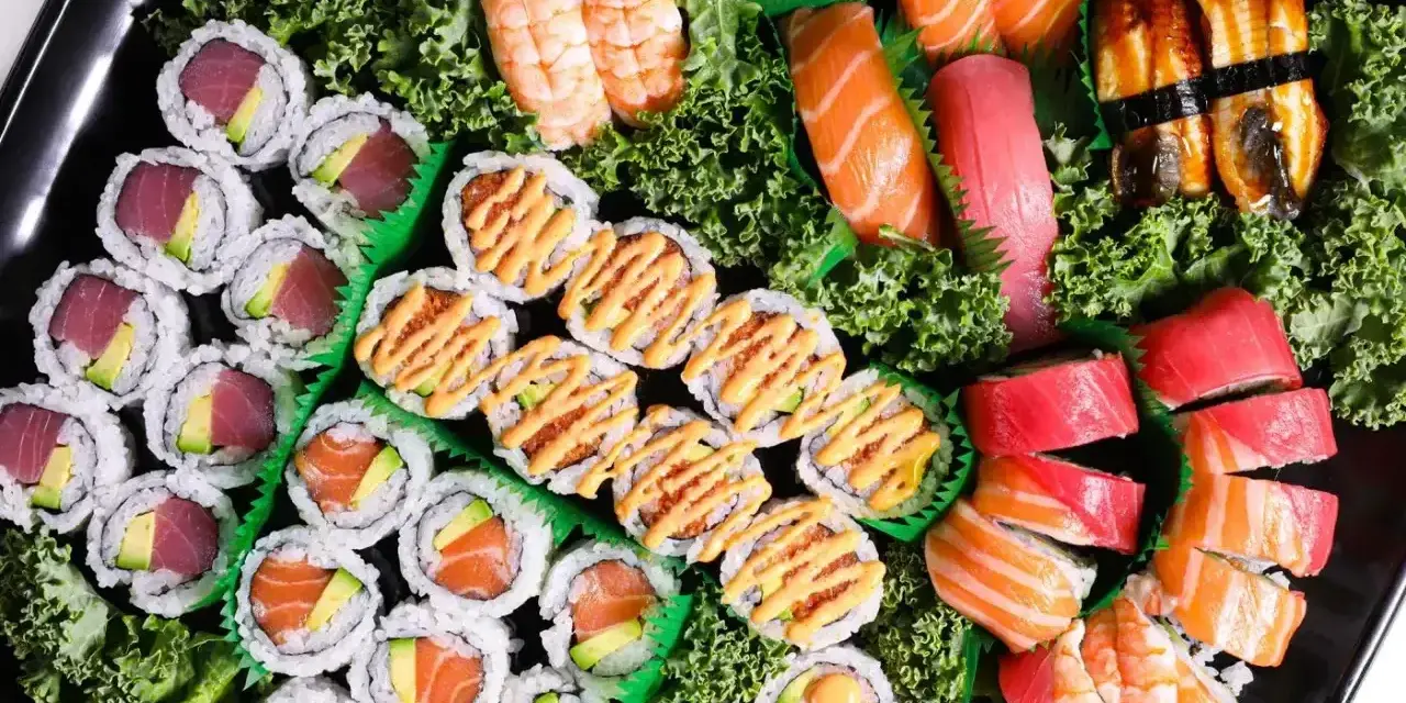 Taca pełna sushi z Japonii: rolki z tuńczykiem i awokado, łososiem, krewetkami, nigiri z łososiem, tuńczykiem i węgorzem.