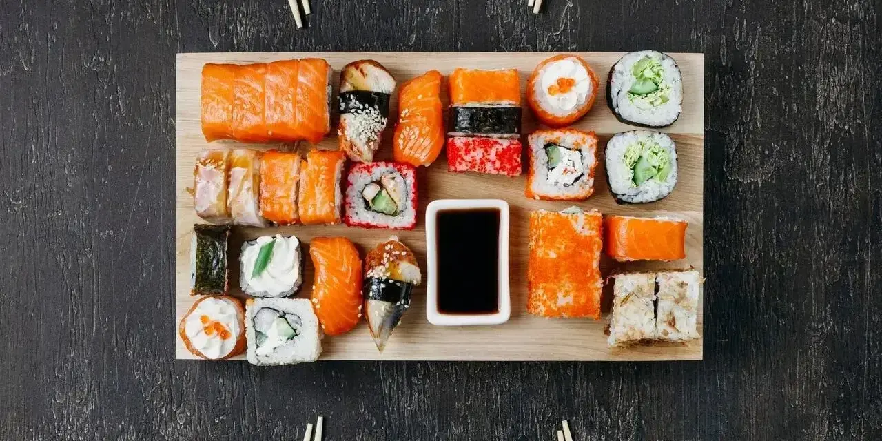 Na desce ułożono różnorodne sushi. Ile kawałków sushi na osobę? Zależy od apetytu, ale jest tu spory wybór!