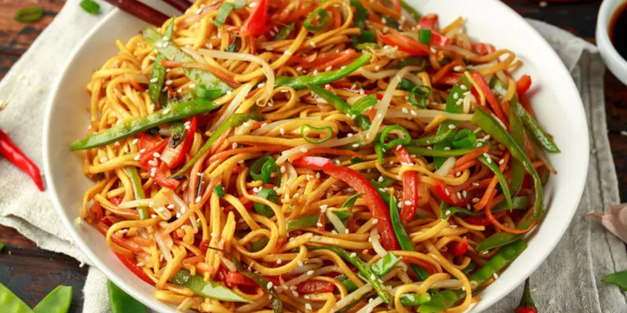 Miseczka makaronu chow mein z warzywami i pałeczkami.