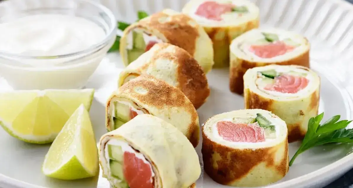 Sushi w naleśniku: rolki z łososiem, ogórkiem i serkiem, podane z dipem i limonką.