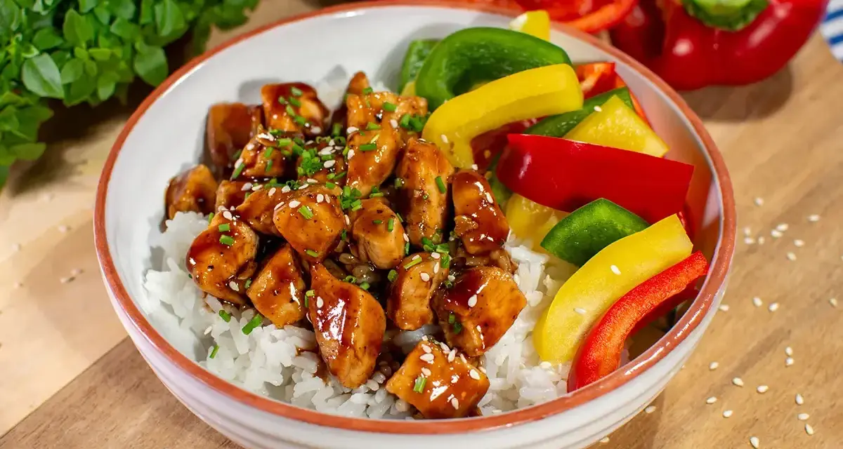 Pyszny kurczak z gotowym sosem teriyaki na ryżu, z kolorową papryką i szczypiorkiem.