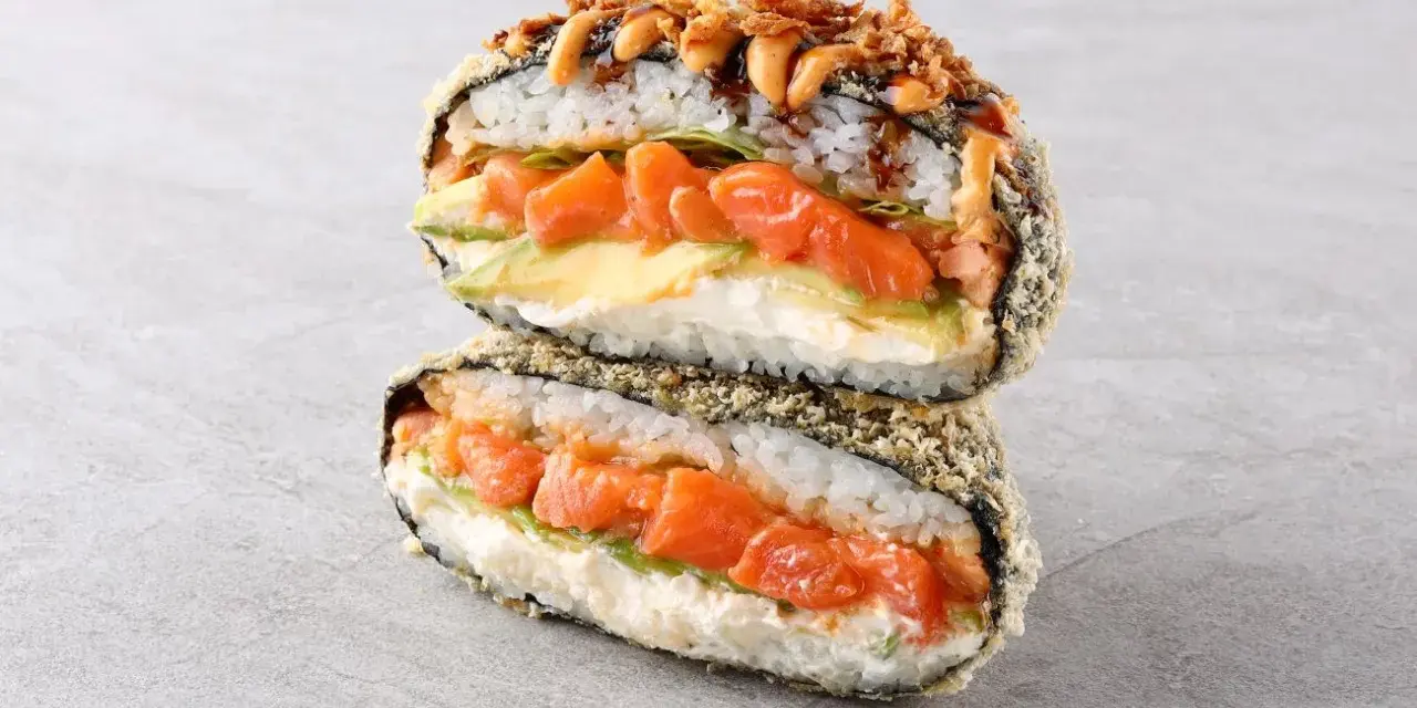 Sushiburger z łososiem, awokado i kremowym serkiem, otoczony chrupiącą panierką z ryżu i nori.