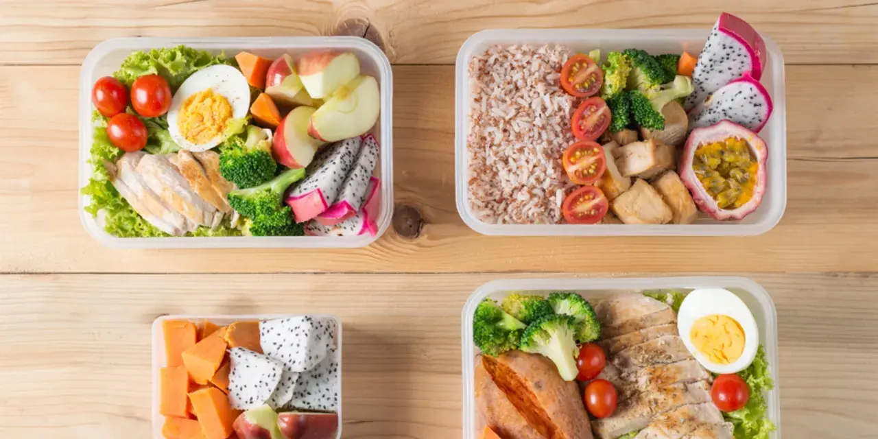 Cztery pudełka bento z kurczakiem, ryżem, warzywami i owocami. Idealne na zdrowy lunch, pokazują, bento co to jest.
