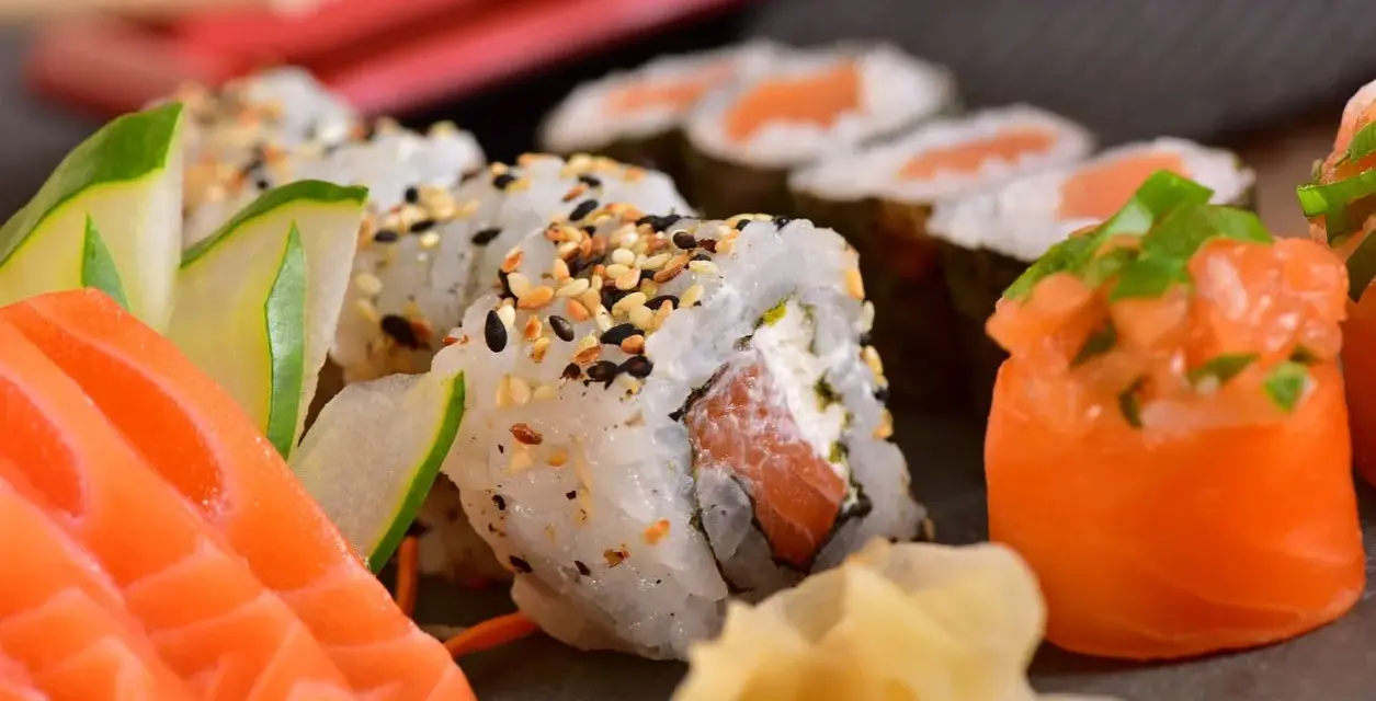Pyszne sushi z łososiem, ogórkiem i sezamem. Choć ryby morskie zawierają zdrowe tłuszcze, warto pamiętać o umiarkowanym spożyciu, zwłaszcza jeśli dbamy o poziom cholesterolu.
