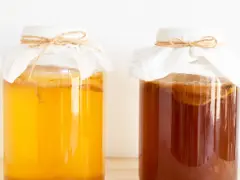 Dwa słoje z kombuchą, jeden jasnożółty, drugi ciemnobrązowy. Zastanawiasz się nad kombucha szkodliwość?