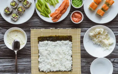 Idealny ryż do sushi jest kleisty i gotowy do zwinięcia z nori, łososiem i awokado.