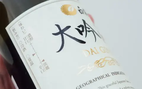 Butelka sake Dai Ginjo. Na etykiecie widnieje informacja o zawartości alkoholu, smakach i sposobie podania.