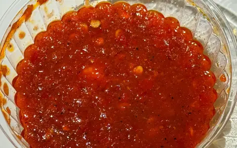 Ostre, czerwone sambal w przezroczystym pojemniku. Idealne do potraw, gdy zastanawiasz się, sambal co to jest i chcesz dodać pikanterii.