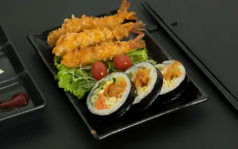 Chrupiące krewetki i rolki sushi z krewetkami, podane z pomidorkami i sałatą. Idealne na przekąskę nigiri krewetka.