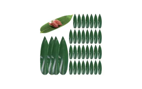 Zielone liście do sushi, jeden z nich ozdobiony dwoma kawałkami nigiri.