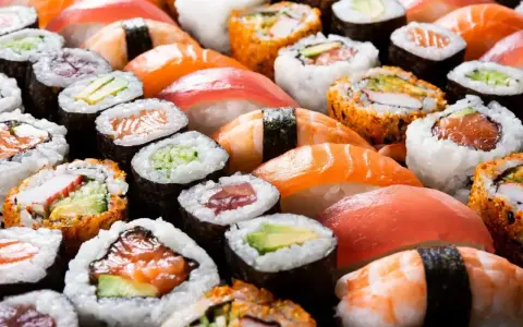 Różnorodne sushi, w tym rolki z łososiem i awokado, idealne dla dzieci. Czy dzieci mogą jeść sushi? Tak, jeśli wybierzemy łagodne składniki!