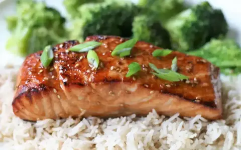 Łosoś w sosie teriyaki na ryżu z brokułami, posypany sezamem i szczypiorkiem. Pyszne danie.