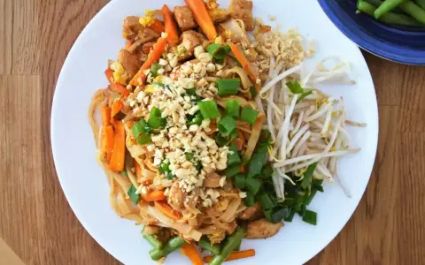 Pyszny pad thai oryginalny przepis z kurczakiem, warzywami i orzeszkami ziemnymi.