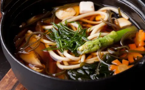 Gęsta zupa z grubym makaronem udon, tofu, warzywami i wodorostami w aromatycznym bulionie dashi.