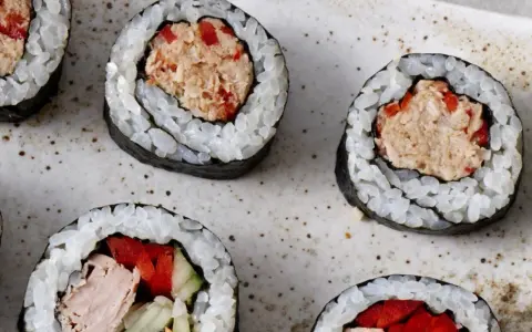 Roladki sushi z ryżem, nori i pyszną pastą z tuńczyka z dodatkiem czerwonej papryki. Idealne na szybką przekąskę.