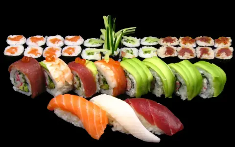 Różnorodne sushi: nigiri z łososiem, tuńczykiem i kalmarem, rolki z awokado, krewetką, tuńczykiem i krabem. Idealne na początek przygody, jak jeść sushi.