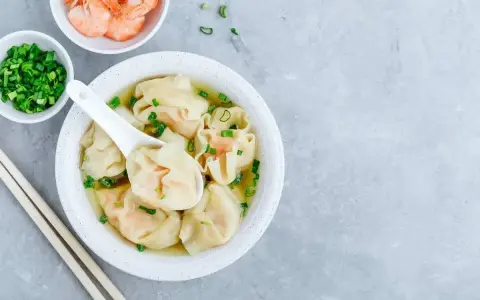 Aksamitna zupa won ton z krewetkami i szczypiorkiem, gotowa do zanurzenia się w jej smaku.