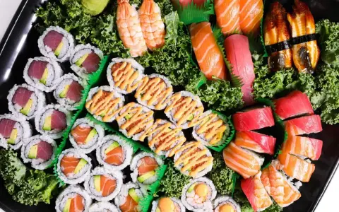 Taca pełna sushi z Japonii: rolki z tuńczykiem i awokado, łososiem, krewetkami, nigiri z łososiem, tuńczykiem i węgorzem.