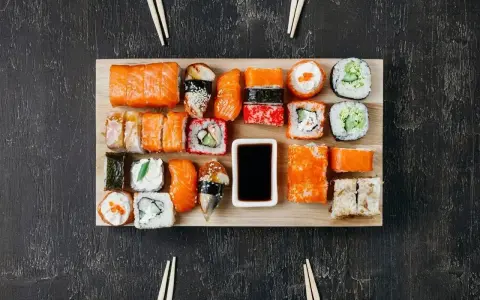 Na desce ułożono różnorodne sushi. Ile kawałków sushi na osobę? Zależy od apetytu, ale jest tu spory wybór!
