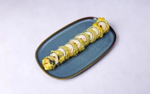 Rząd chrupiących roladek sushi w cieście tempura, ułożonych na niebieskim talerzu.