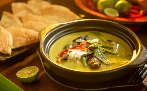 Zielone curry z bakłażanem i papryką, podane z chlebkiem naan i limonką. Jedne z wielu pysznych rodzajów curry.